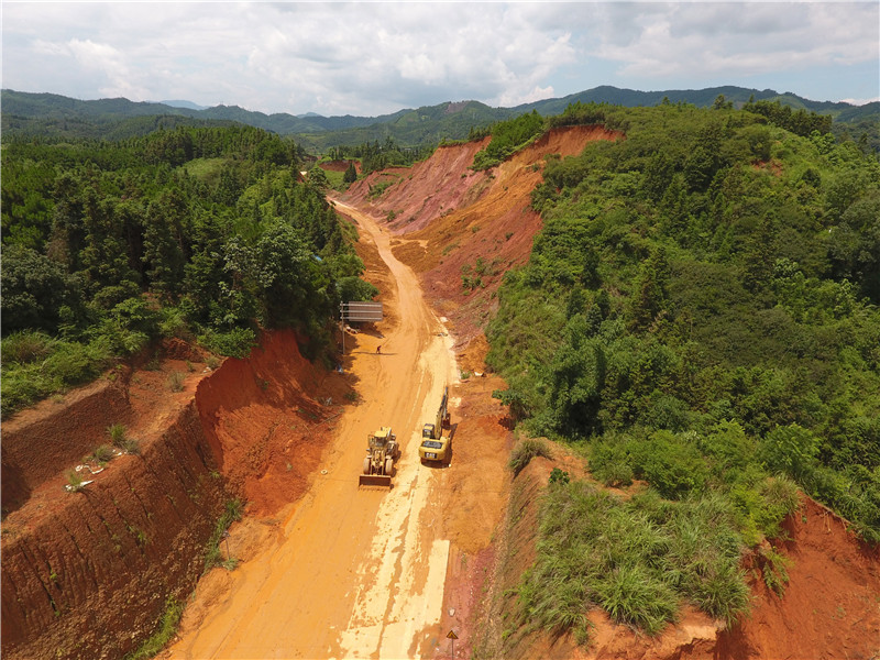 7月13日，工程機械在廣西三江侗族自治縣古宜鎮搶修塌方中斷的道路。
