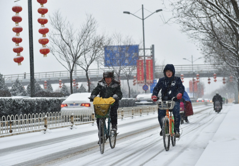 2月21日，在太原市濱河東路，兩位市民冒雪騎行。