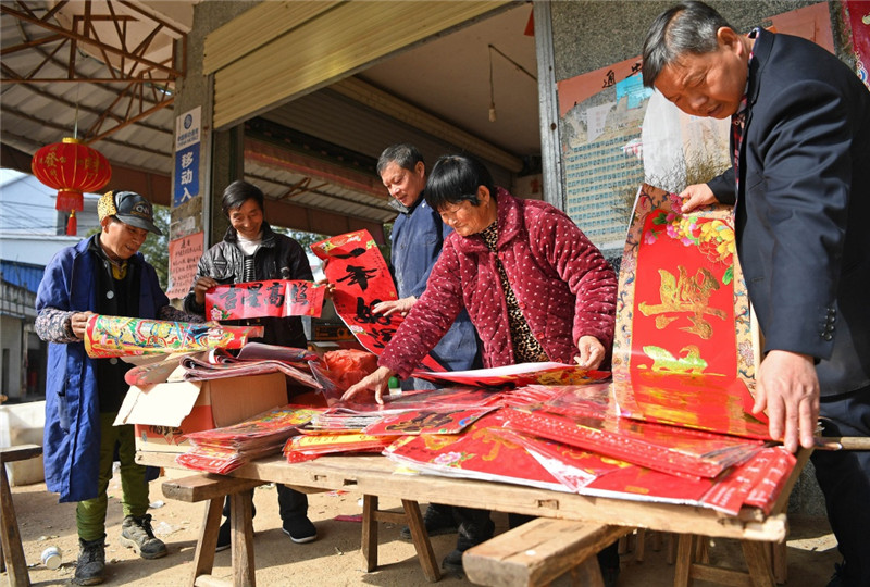 江西鄱陽縣古縣渡鎮張家坽村村民在集市上選購春聯（1月24日攝）。