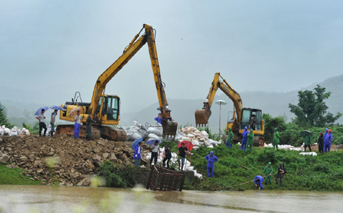 7月5日，在岳陽市云溪區，工作人員在一處堤壩隱患處加緊搶修。連日來，湖南省遭遇嚴重暴雨洪澇災害，當地干部群眾齊心協力搶險救災。記者4日從湖南省防汛抗旱指揮部了解到，據初步統計，本輪強降雨共造成湖南省長沙、常德、岳陽等9市州36個縣市區317個鄉鎮52.23萬人受災，緊急轉移4.09萬人，倒塌房屋600間。湖南省防指決定自4日12時起將防汛應急響應提升至二級，益陽、岳陽、常德三市為當前防汛抗災工作重點區域，要求各級各部門按照應急響應要求，切實做好防汛抗洪各項工作。