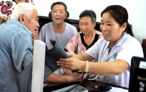 7月12日，肥西縣上派鎮中心衛生院醫生郭曉（右一）為轉移到安置點的群眾進行醫療服務。7月初，安徽省肥西縣遭遇大到強暴雨襲擊，內澇嚴重，受災人口近20萬人，全縣緊急轉移群眾1.4萬人，設置受災群眾安置點8個，不僅保障受災群眾的基本生活，還跟蹤建立安置點的基本公共衛生服務，受災群眾對移動的“民生工程”表示肯定。新華社記者 陶明 攝