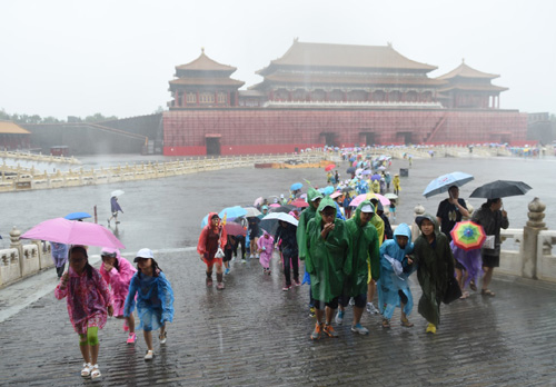 7月20日，游客冒雨在北京故宮游覽。北京市氣象臺7月20日8時40分更新發布暴雨黃色預警，預計20日本市大部分地區仍有暴雨、局地大暴雨。