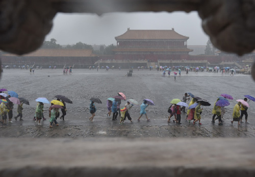 7月20日，游客冒雨在北京故宮游覽。