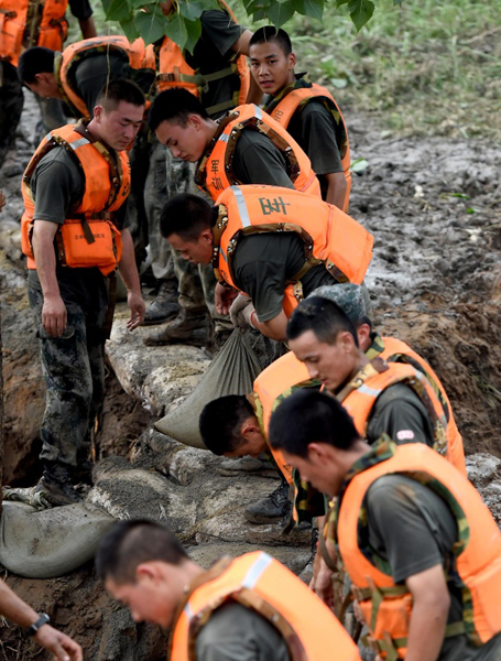 7月21日，在河南省安陽市安陽河崇義段堤壩決口處，解放軍官兵用沙袋封堵決口。7月20日下午，河南省安陽市安陽河崇義段堤壩出現決口險情，400多名解放軍官兵趕到現場后，連續奮戰，堅守在封堵決口第一線。新華社記者 李安 攝
