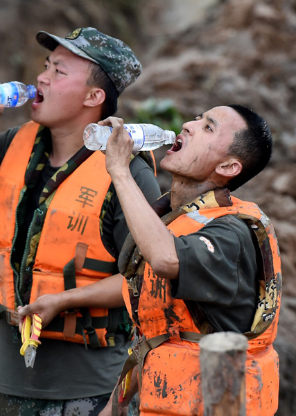 7月21日，在河南省安陽市安陽河崇義段堤壩決口處，解放軍戰士在搶險間歇喝水。新華社記者 李安 攝