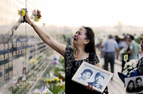 7月28日，一名女士在唐山大地震罹難者紀念墻悼念遇難者。新華社記者 吳曉凌 攝