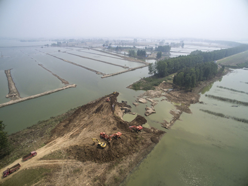 8月17日，工作人員在對漢北河胡市段河堤潰口處進行封固。 今年汛期以來，湖北多地受嚴重洪澇災害影響，損失巨大。各受災地區的災后重建工作也在洪水消退后陸續開展。湖北天門、京山等受災最嚴重的地區，部分受災農田已完成復播，水毀道路正在修復，潰口的河堤正在加緊封固，災后重建工作有序進行。
