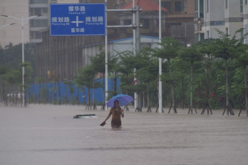 10月13日，海南瓊海市民在雨中出行。