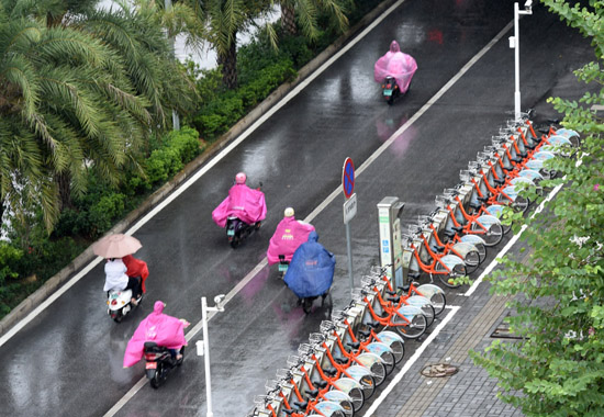 10月18日，市民在南寧市濱湖路冒著風雨出行。當日，受臺風“莎莉嘉”影響，廣西南寧、崇左、欽州、防城港、玉林、貴港等地發布臺風預警信號。