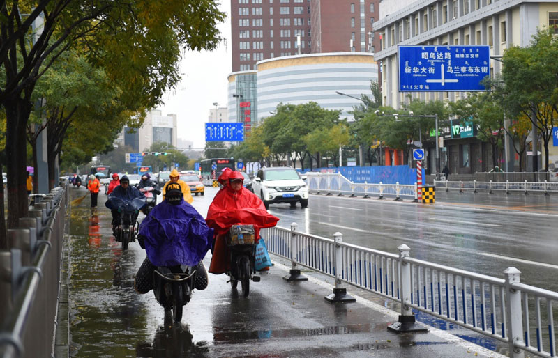   10月27日，在呼和浩特街頭，出行者在雨中駕車行駛。