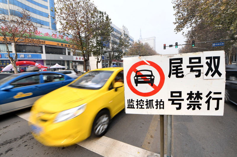 12月3日，車輛從河北省邢臺市守敬北路上的限號提示牌旁經過。
