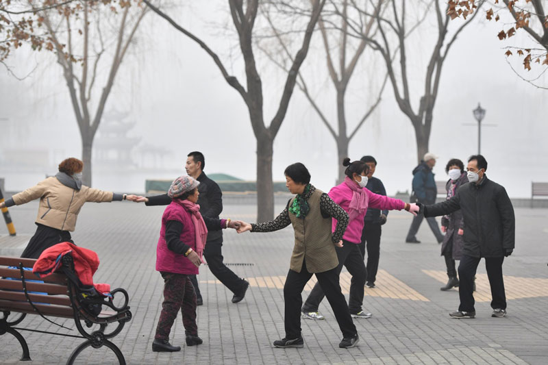 12月21日，市民在霧霾籠罩的陶然亭公園內跳舞。