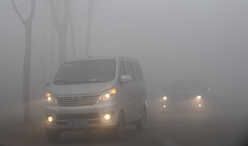 12月22日，車輛在霧霾籠罩下的河北省大城縣的一條公路上緩慢行駛。當日，河北南部局部地區出現重度霧霾天氣給當地交通和人們出行帶來了不便。