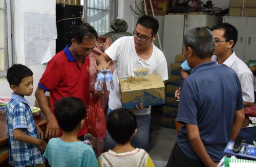 8月2日，在廣西蒼梧縣沙頭鎮參田村小學，當地村民領取物資準備在這里臨時安置。當日，臺風“妮妲”中心在廣東登陸后從蒼梧縣進入廣西境內。根據梧州氣象臺預報，“妮妲”過境時中心附近最大風力8級，并帶來大量雨水，臺風、強降雨區與蒼梧縣地震震區重疊。當地有關部門將因災受損房屋里的群眾撤離到安全地帶避險。目前，當地政府正加強對危險區域、災害隱患點的巡查和應急處置，嚴防余震和臺風帶來的次生災害。新華社記者 陸波岸 攝